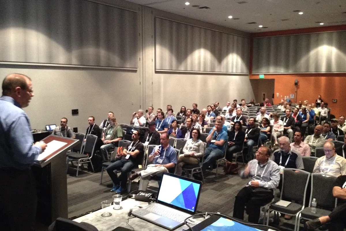A Kaman Industrial Technologies presenter at the lectern in a full conference room, co-presenting their success story with P3